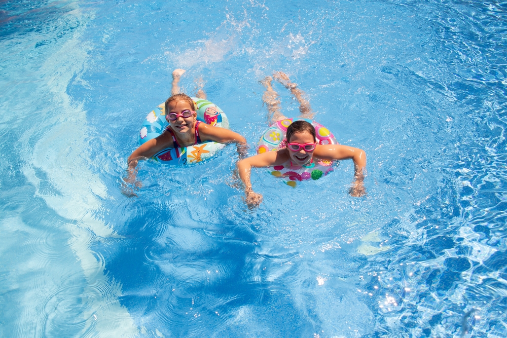 Two,Little,Girls,Play,And,Swim,In,The,Pool